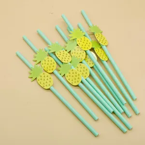 Closeup of disposable biodegradable paper straws with cute tropical pineapple decoration details.
