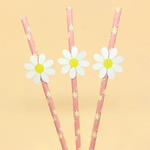 Detailed shot of pink paper drinking straws featuring cute white daisy patterns and 3D flower cutouts.