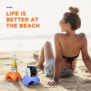 Beach cup holders detail showing plastic sand bases holding drinks and phones outdoors.