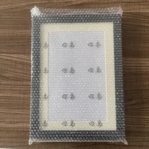 Detailed view of wooden kids art frame with white mat and clear protective bubble wrap packing.