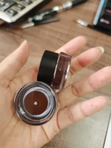 Compact gel eyeliner and eyebrow pomade in small jars, waterproof formula for precise makeup.