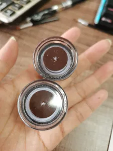 Detailed view of brown gel eyeliner pots in transparent container, perfect for precise eye makeup application.