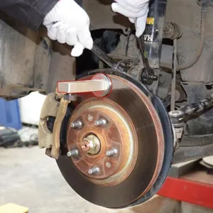 Detailaufnahme der magnetischen Sturz-Einstelllehre an der Bremsscheibe für exakte Achsvermessung.