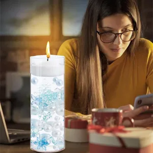 Detailed scene of floating candle vase filler with pearls and blue snowflakes for decor.