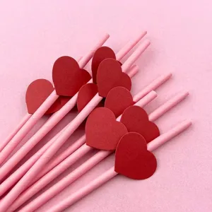 Cannucce di carta rosa con decorazioni a cuore rosso perfette per feste e bevande.
