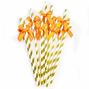 Gold striped paper straws with orange bows for party decorations and birthday celebrations.
