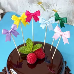 Colorful ribbon bow cake toppers, baking party dessert decoration close-up detail view.