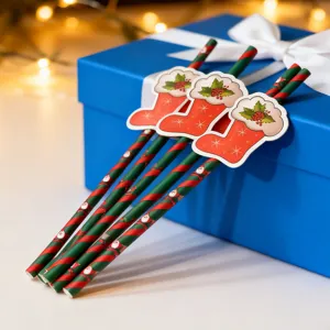 Close up view of Christmas paper straws with cute red sock decor on blue gift box.
