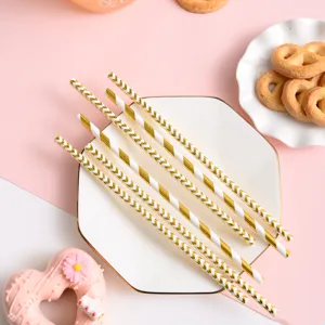 Detailed view of biodegradable gold foil pink paper straws for party table decoration setup.