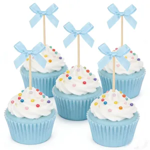 Blue bow cupcake toppers detail shot, fabric bows on wooden picks with cute dessert decoration.