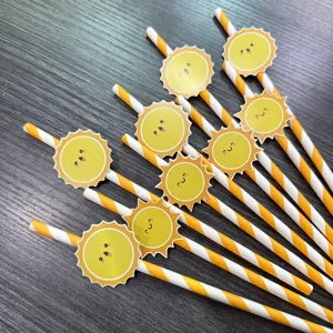 Close-up detail of creative yellow striped paper straws with cute smiling sun decorations for party.
