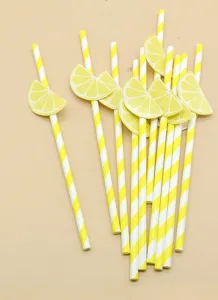Disposable biodegradable paper straws with creative lemon fruit slice decorations for drinks.