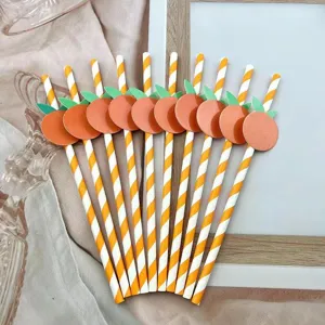 Vista dettagliata di cannucce di carta arancione, biodegradabili con decoro di frutta per feste.