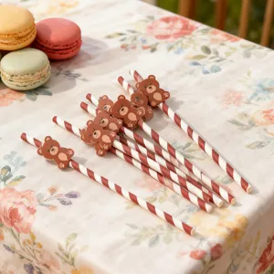 Close-up detail of cute brown bear paper straws with red and white stripes for party decor.