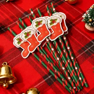 Close-up detail of festive Christmas paper straws featuring cute stocking designs on plaid table.