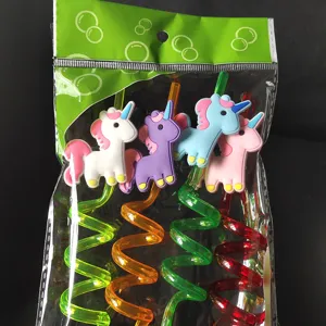Close-up detail of cute cartoon unicorn PVC charm on colorful spiral drinking straw set.