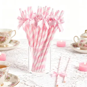 Nahaufnahme rosa-weißer Papierstrohhalme mit edlen Satin Schleifen für Party und Desserttisch.