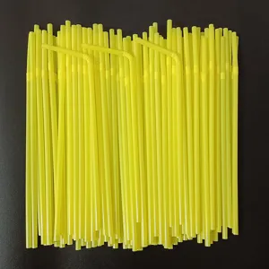 Gedetailleerde close-up van netjes gerangschikte gele plastic rietjes in een bundel.