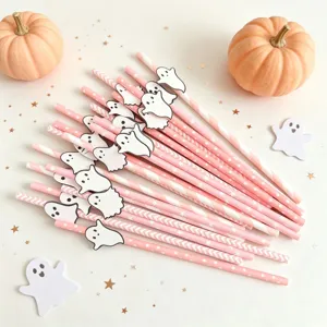 Close-up detail shot of pink and white striped paper straws with cute ghost cutouts for party.