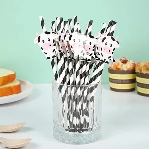 Close-up detail of cute black and white striped paper straws with lovely cow cutouts.