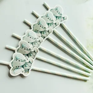Close-up detail of cute watercolor elephant paper straws and cake toppers for party decoration.