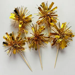 Detailed close-up view of golden tinsel firework cake topper picks for party desserts.