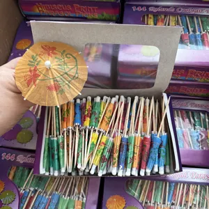 Cocktail umbrella picks detail view showing colorful paper parasols with wooden sticks in box.