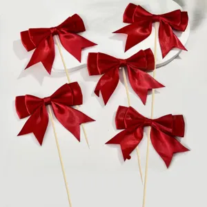 Red satin bow cake toppers detail view, perfect for wedding, birthday, and party dessert decorations.