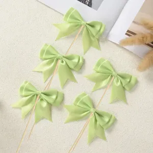 Light green satin ribbon bow cake toppers for baking party dessert decoration details.