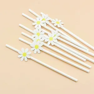 Close up detail of white paper drinking straws decorated with cute yellow and white daisy flowers.