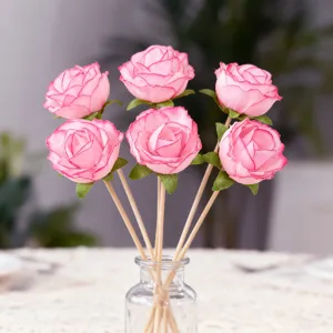 Gedetailleerd overzicht van creatieve roze kunstroos bloemprikkers, houten stokje voor desserts.