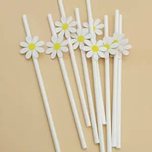Detailed shot of white paper drinking straws with cute paper daisy flower decorations for party.
