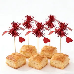 Valentine heart decorative pick detail close-up showing red tinsel and wooden stick on pastry.