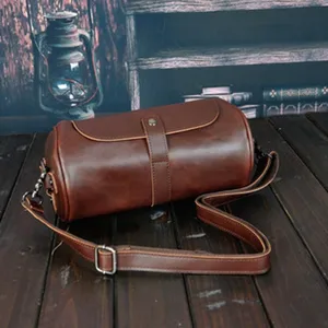 Detailansicht der braunen Vintage-Leder-Zylindertasche mit feiner Textur und robustem Riemen.