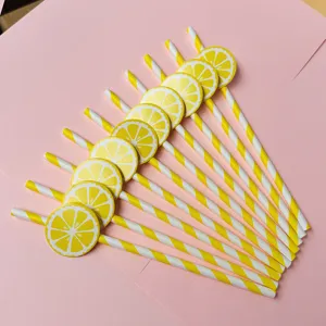 Detailansicht von gelb-weißen gestreiften Papierstrohhalmen mit niedlichen Zitronenscheiben.