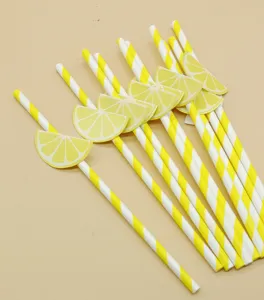 Close-up detail of disposable paper drinking straws featuring yellow stripes and cute lemon slice decorations.