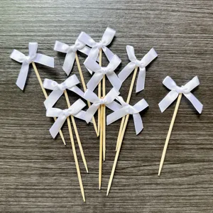 White ribbon bow cake toppers detail view, fabric bow bamboo picks for party dessert decoration.
