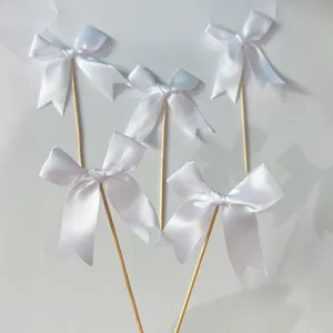 White satin ribbon bow cake toppers with wooden sticks for birthday party baking dessert decorations.