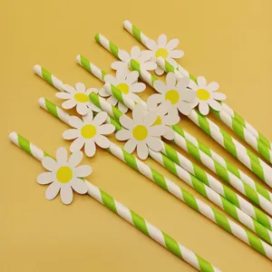 Detail shot of green and white striped paper straws with cute daisy flower decorations for party.