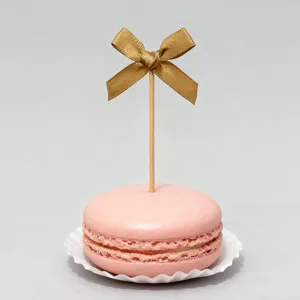 Gold bow cake topper, elegant ribbon dessert pick for baking and birthday party decoration.