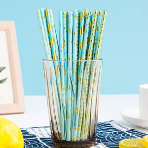 Gedetailleerde close-up van blauwe en gouden papieren rietjes in een helder glas.