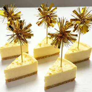 Gold tinsel firework cake picks detail view, sparkling dessert toppers for party decoration.