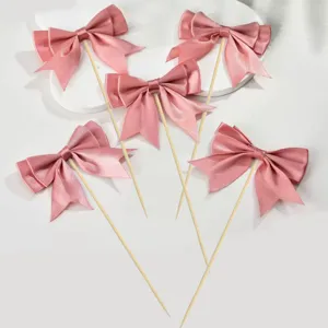 Pink satin bow cake toppers detail view, perfect for birthday baking party dessert decoration.