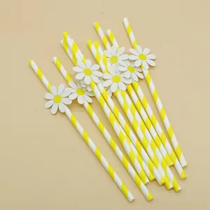 Close up of yellow striped paper straws with cute white daisy decorations for party events.