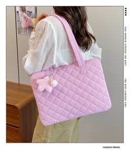 Detailed view of the pink quilted laptop bag with a cute star plush pendant for daily commute.