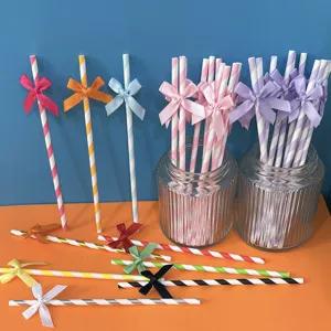 Cannucce di carta a righe colorate con fiocchi, perfette per feste di compleanno e tavoli dolci.