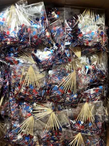 Close-up detail view of bulk patriotic firework picks, tinsel star cake toppers for party decor.