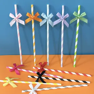 Cannucce di carta a righe colorate con fiocco per decorazione di tavola da festa e dettagli.