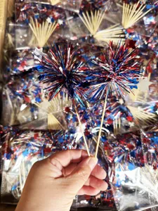 Detail shot of US Independence Day patriotic firework cake toppers with red white and blue tinsel.