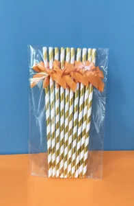 Cannucce di carta oro e bianche a righe con fiocco per decorazione di feste ed eventi.